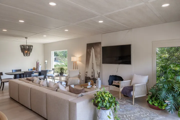 Open-concept living area featuring light-toned flooring, recessed lighting, and a textured ceiling. Textured fireplace with a built-in media alcove, Italian Marble Slab,Crema Marfil, Hydrofinish, The only hydrofinished slab ever sold in utah.