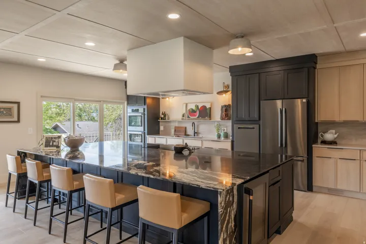 Expansive kitchen island featuring a polished stone countertop and integrated seating