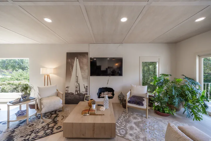 Recessed lighting illuminating a paneled ceiling, wide plank wood-finish flooring, and a built-in fireplace. Textured fireplace with a built-in media alcove, Italian Marble Slab,Crema Marfil, Hydrofinish, The only hydrofinished slab ever sold in utah.
