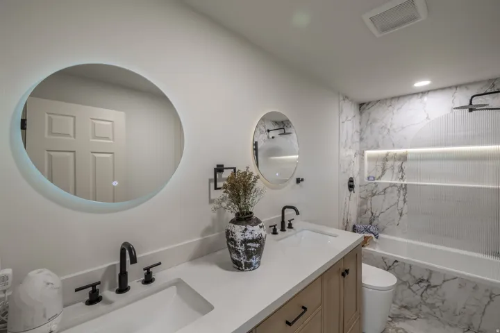Dual vanity with undermount sinks, stone countertops, and matte black fixtures