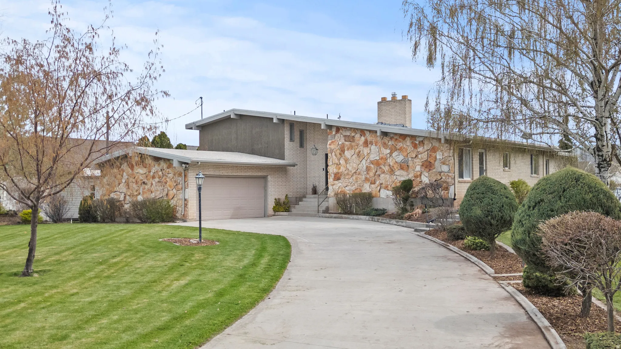 Modern architectural residence showcasing a composed stone and stucco exterior with clean geometric lines