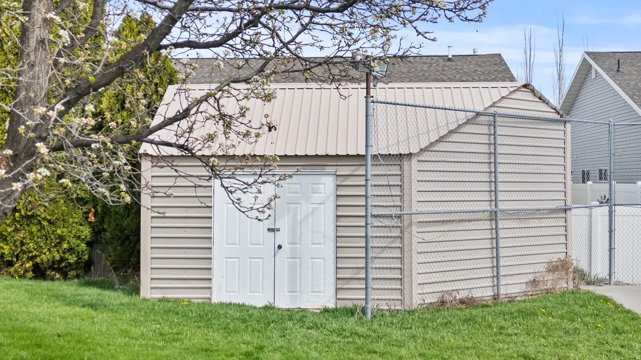 Detached storage shed featuring horizontal siding and a metal roof
