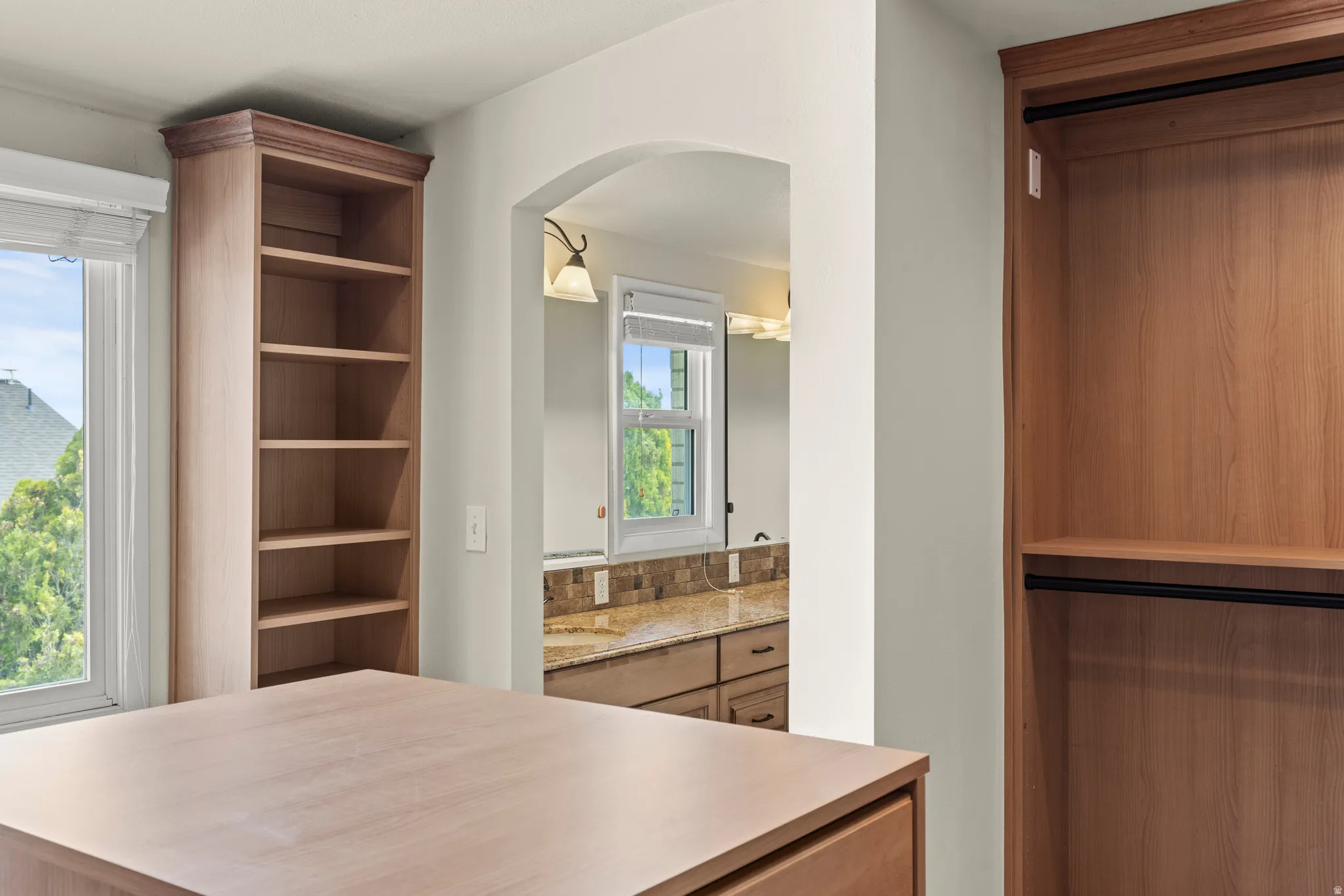 Built-in wood-finish cabinetry featuring open shelving and a dedicated hanging wardrobe