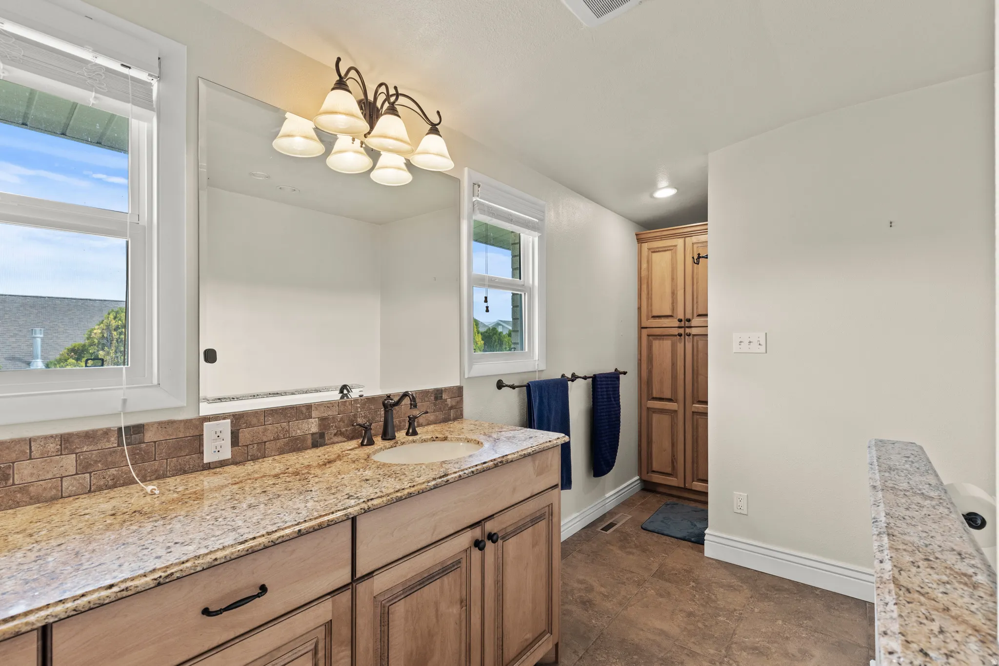 Vanity area featuring a granite countertop, undermount sink, and oil-rubbed bronze faucet