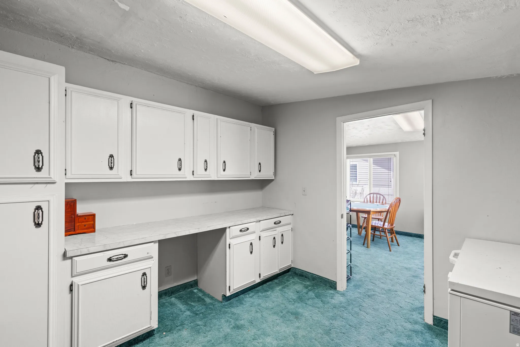 Spacious kitchen featuring white cabinetry with ample storage, vintage-style appliances including a gas range and electric oven, tiled countertops, and turquoise tile flooring