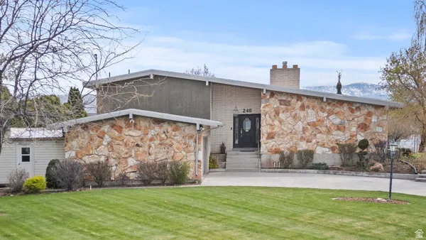 Modern ranch-style residence featuring a striking mixed-material exterior of stacked stone and horizontal siding