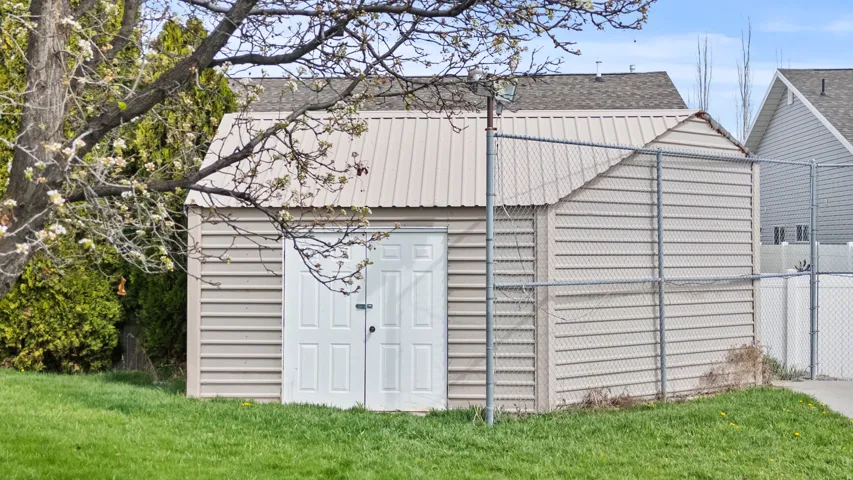 Detached storage shed featuring horizontal siding and a metal roof
