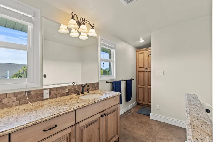 Vanity area featuring a granite countertop, undermount sink, and oil-rubbed bronze faucet