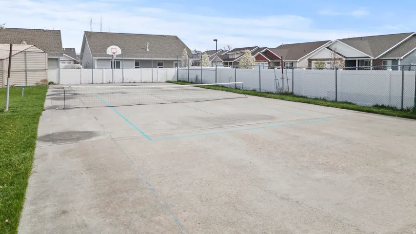 Outdoor concrete court featuring a net and painted lines for recreation