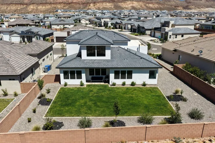 Modern residence featuring a striking dual-gable roofline with charcoal composite shingles, clean white exterior walls, and expansive front-facing windows