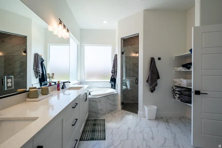 Dual vanity with stone-finish countertops, undermount sinks, and matte black fixtures