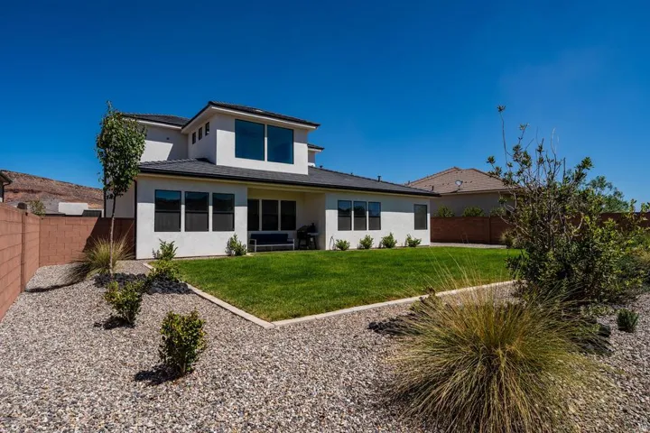 Modern two-story residence featuring a clean-lined white exterior with dark-framed windows and a pitched roofline