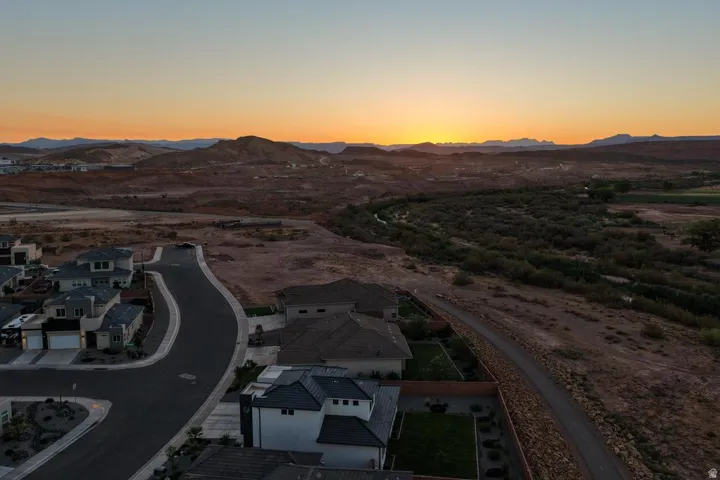 Curved street leading to modern homes with paved driveways and integrated garages