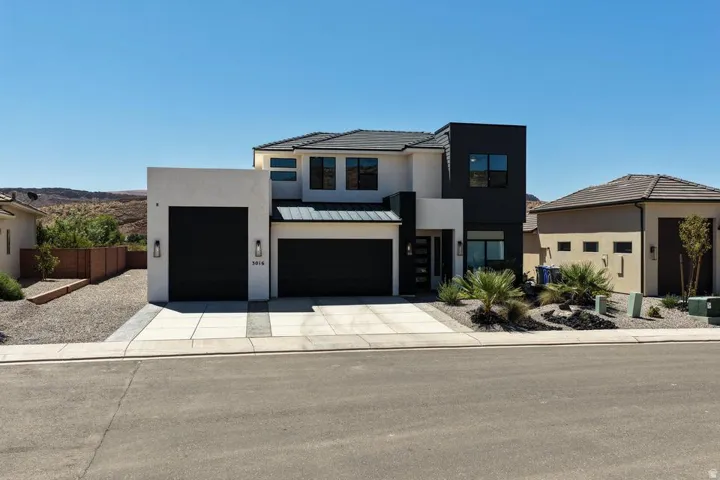 Modern two-story residence featuring a striking contemporary design with contrasting black and light-toned exterior finishes