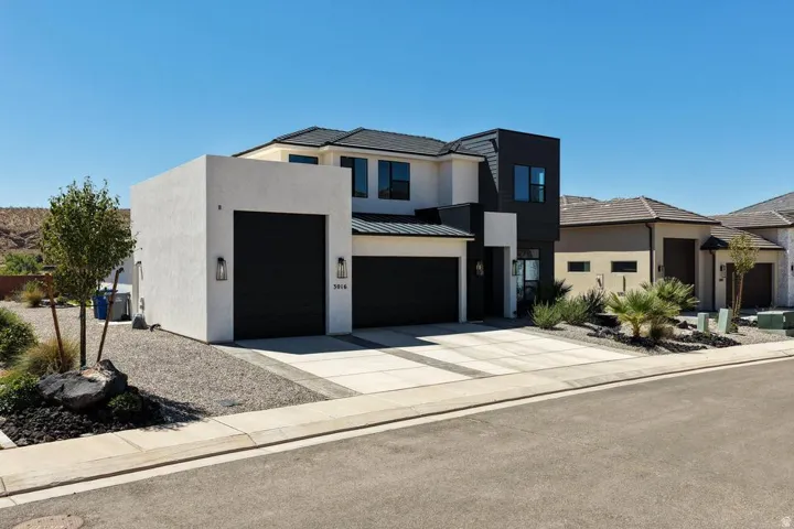 Modern two-story residence featuring a striking contemporary design with contrasting light and dark exterior finishes