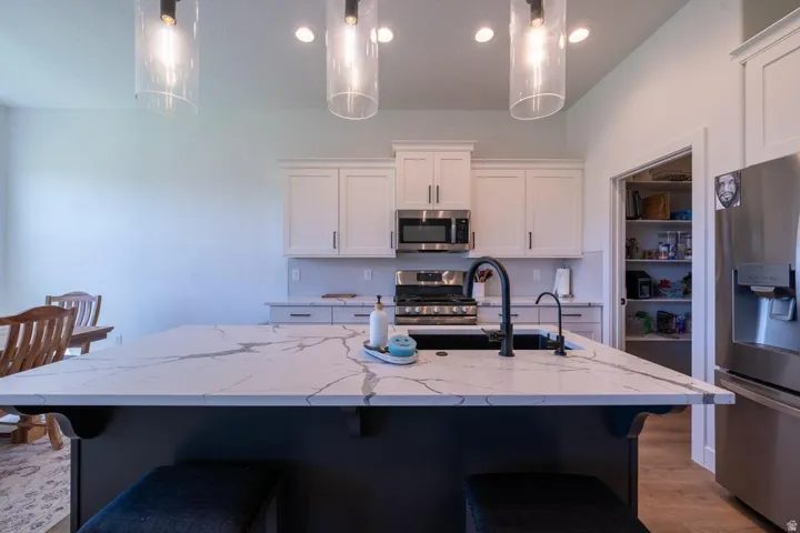 Modern kitchen featuring a spacious island with a white quartz countertop, black base cabinetry, and seating for multiple diners