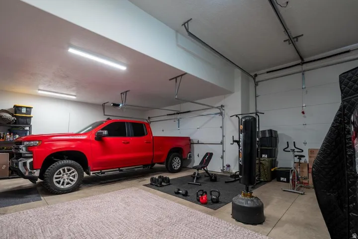 Spacious two-car garage featuring a concrete floor, bright overhead lighting, and two overhead garage doors