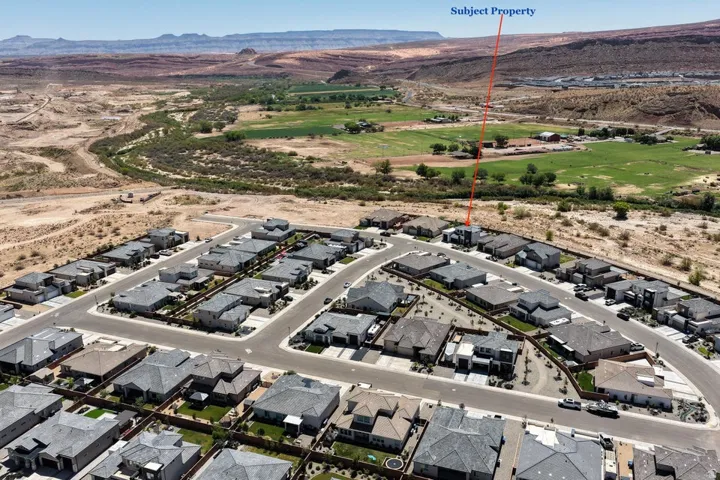 Aerial view of a planned residential community featuring multiple single-family homes with modern architectural design, organized street layouts, and manicured landscaping