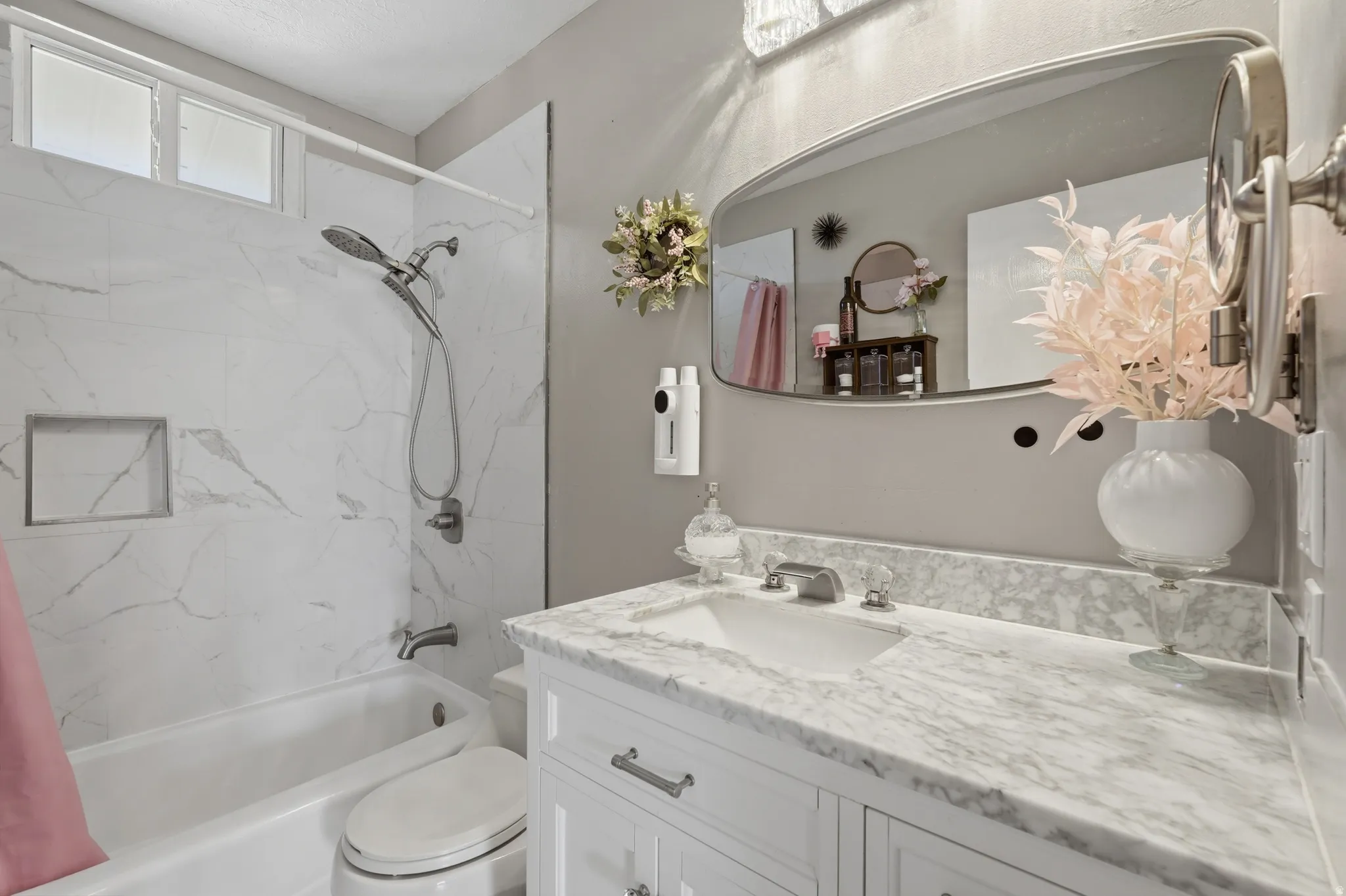 Bathroom featuring a white vanity with a stone-finish countertop, undermount sink, and chrome faucet