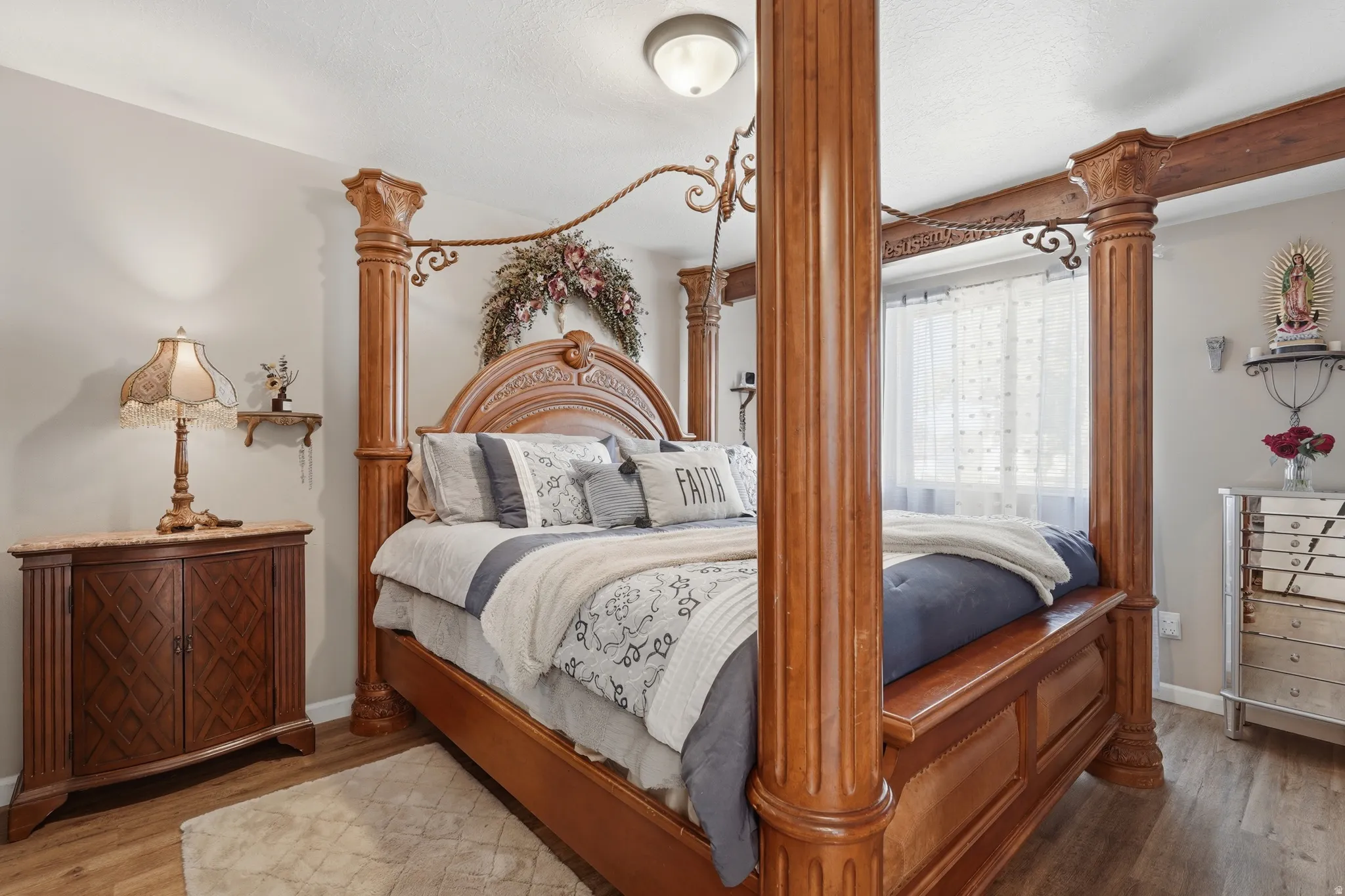 Elegant primary bedroom showcasing a stunning carved wood four-poster bed with decorative finials and ornamental headboard