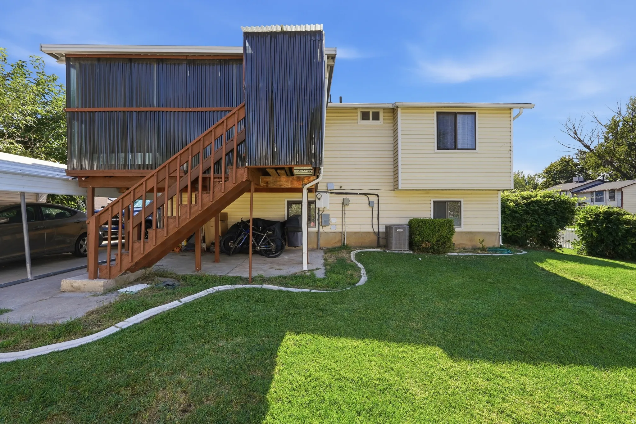 Spacious backyard oasis featuring a manicured lawn, mature landscaping, and established hedging