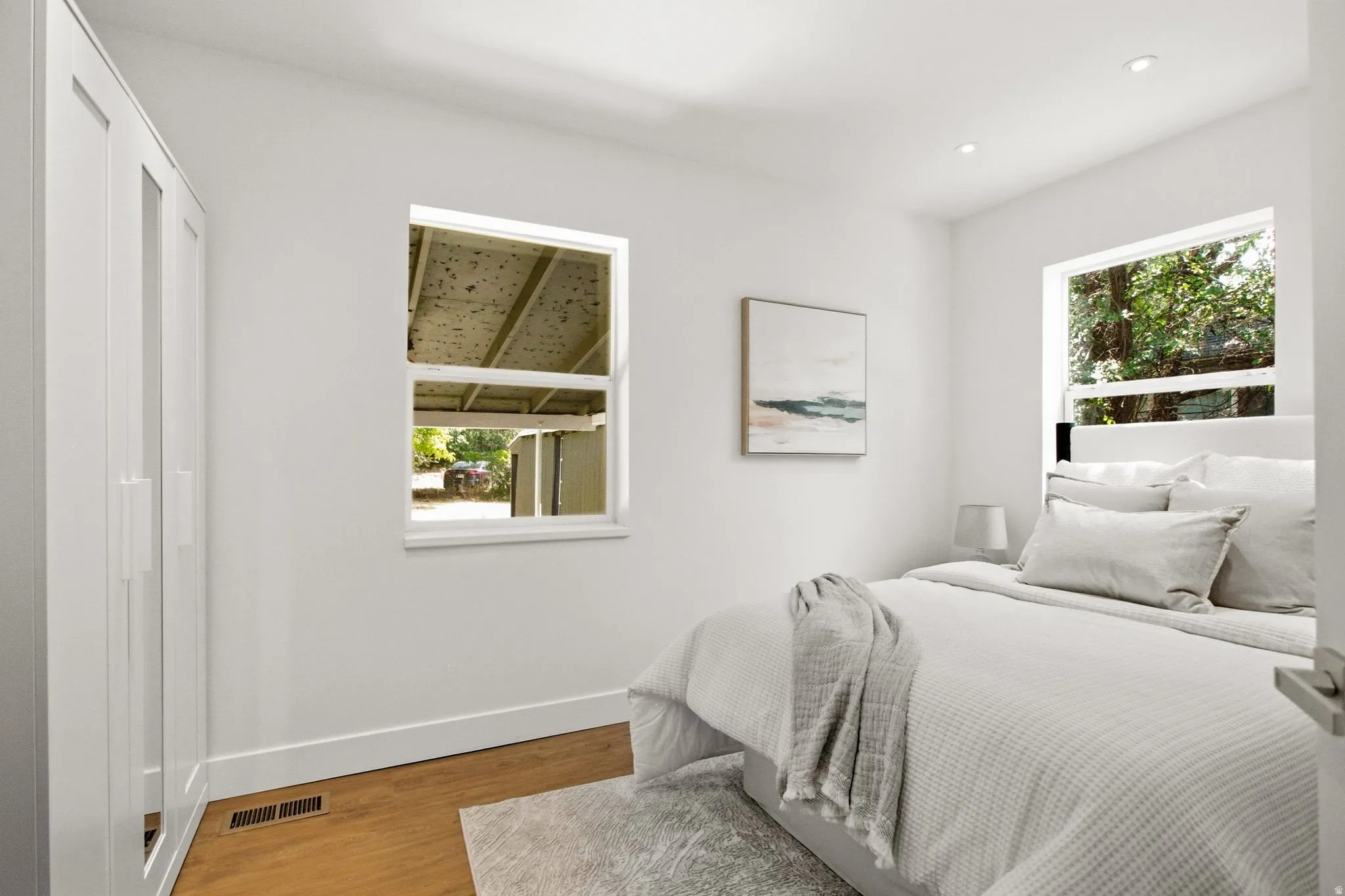 Room featuring light wood-finish flooring, white walls, and recessed lighting