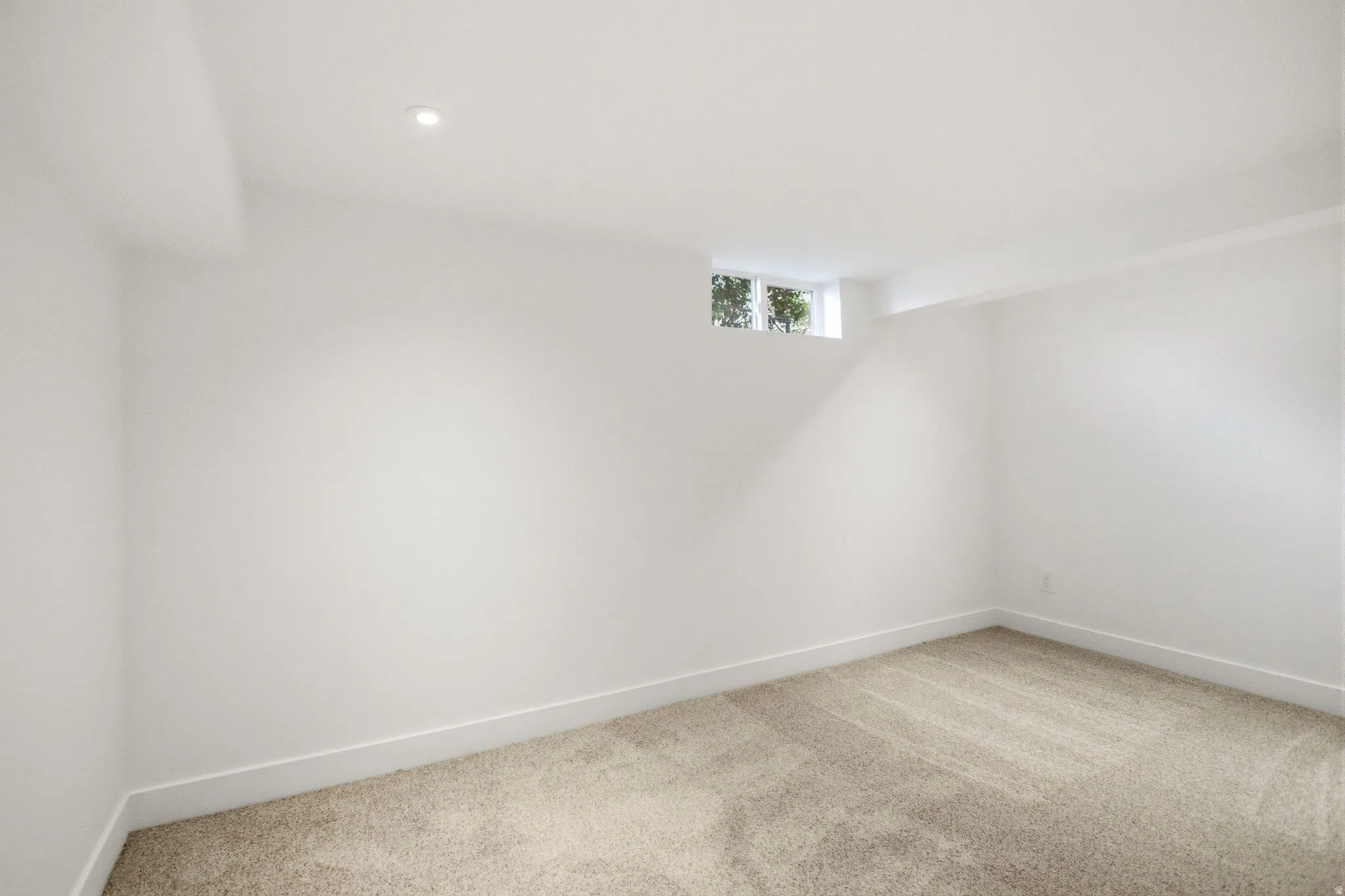 Carpeted room featuring white walls, a recessed ceiling light, and a high-set window