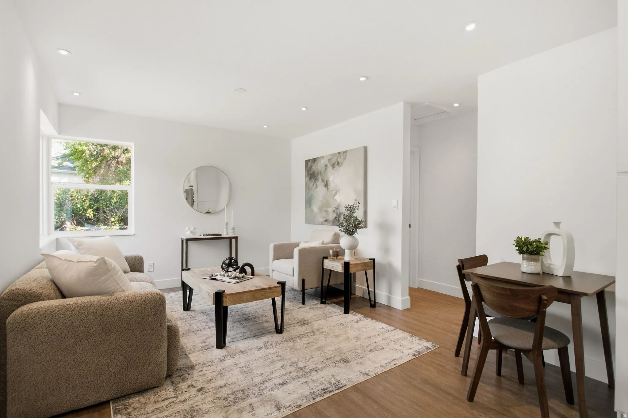 Open-concept living space featuring wood-finish flooring, recessed lighting, and a neutral color palette