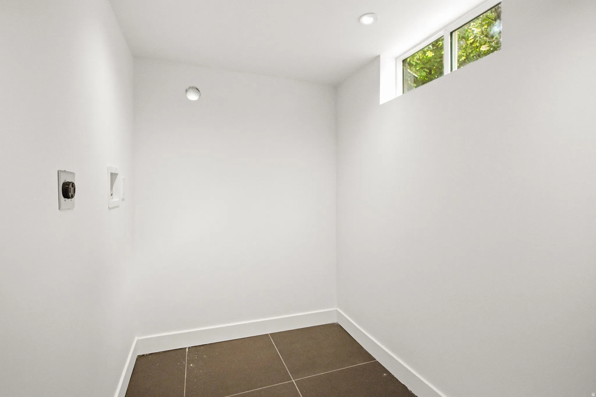 Laundry area featuring a high window, recessed lighting, and tile flooring