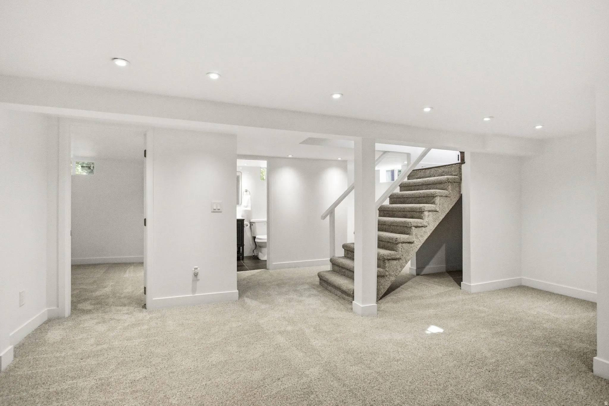 Finished basement space with recessed lighting, carpeted flooring, and white trim