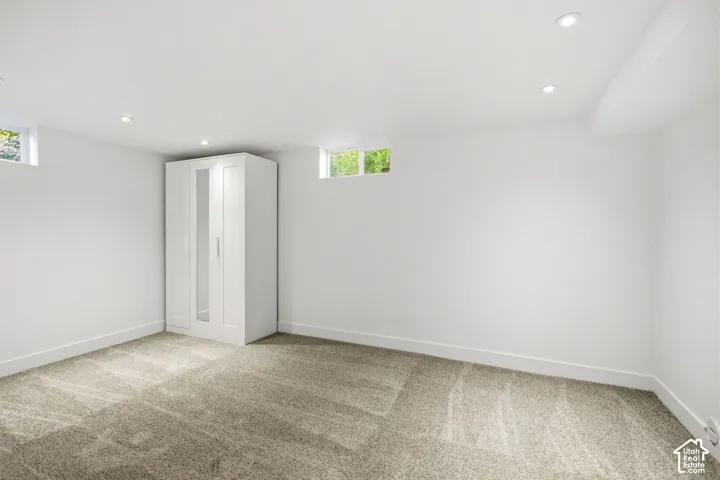Expansive room with neutral carpeting and bright white walls