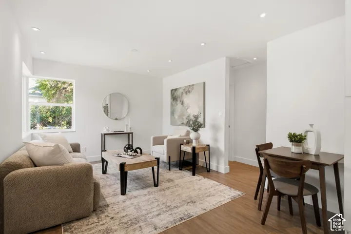Open-concept living space featuring wood-finish flooring, recessed lighting, and a neutral color palette