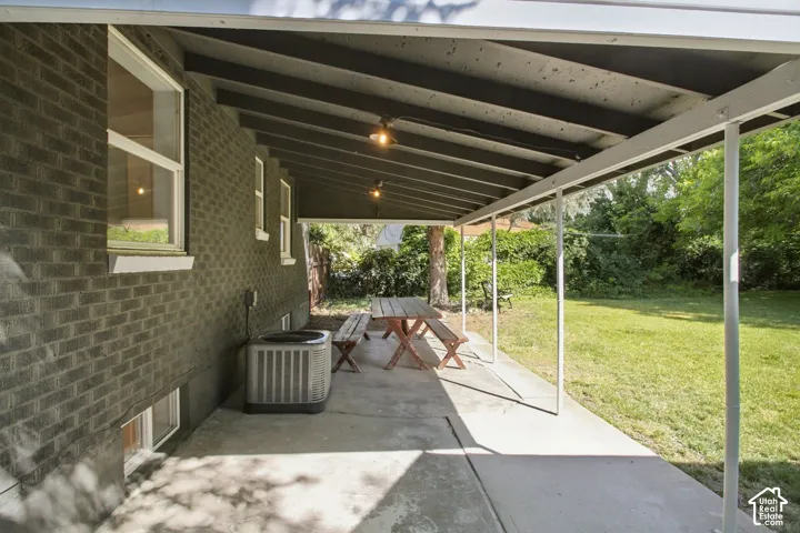Covered concrete patio extending along a brick exterior