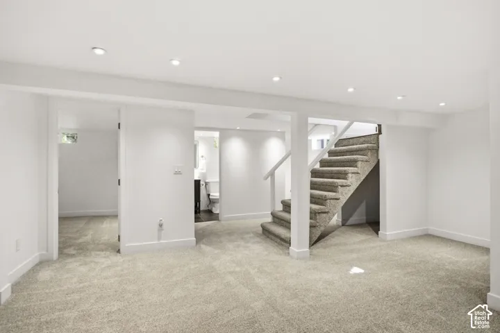 Finished basement space with recessed lighting, carpeted flooring, and white trim