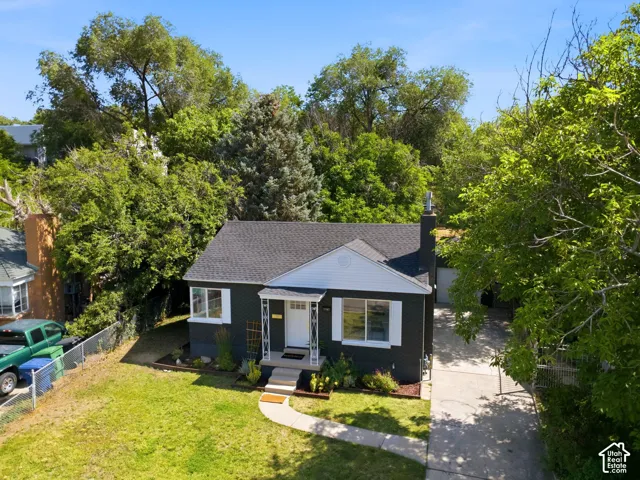 Classic cottage-style home featuring a freshly reshingled roof, black exterior siding, and a covered front porch with white trim detailing