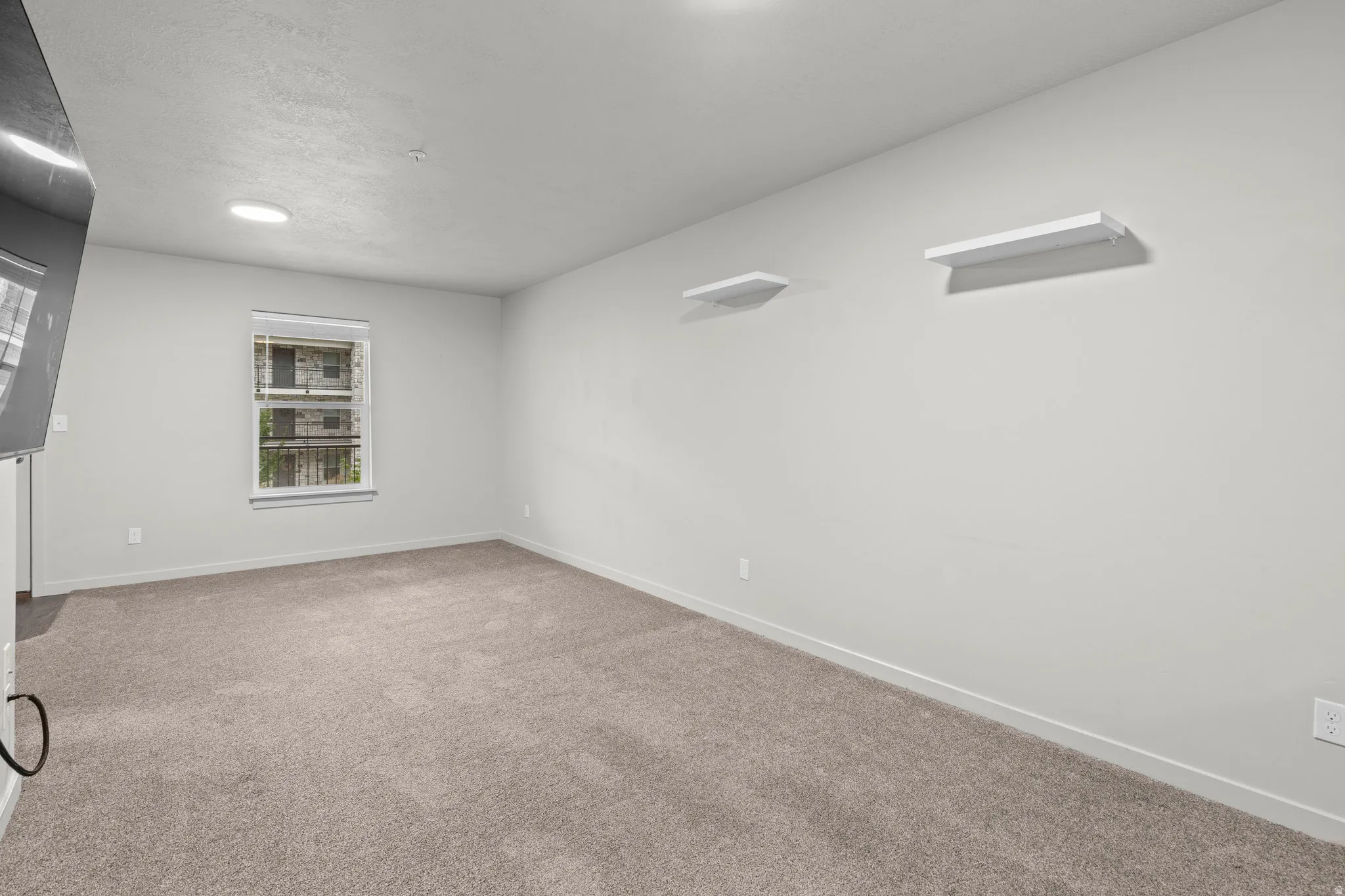 Spacious room featuring neutral wall finishes, recessed ceiling lighting, and plush carpet flooring
