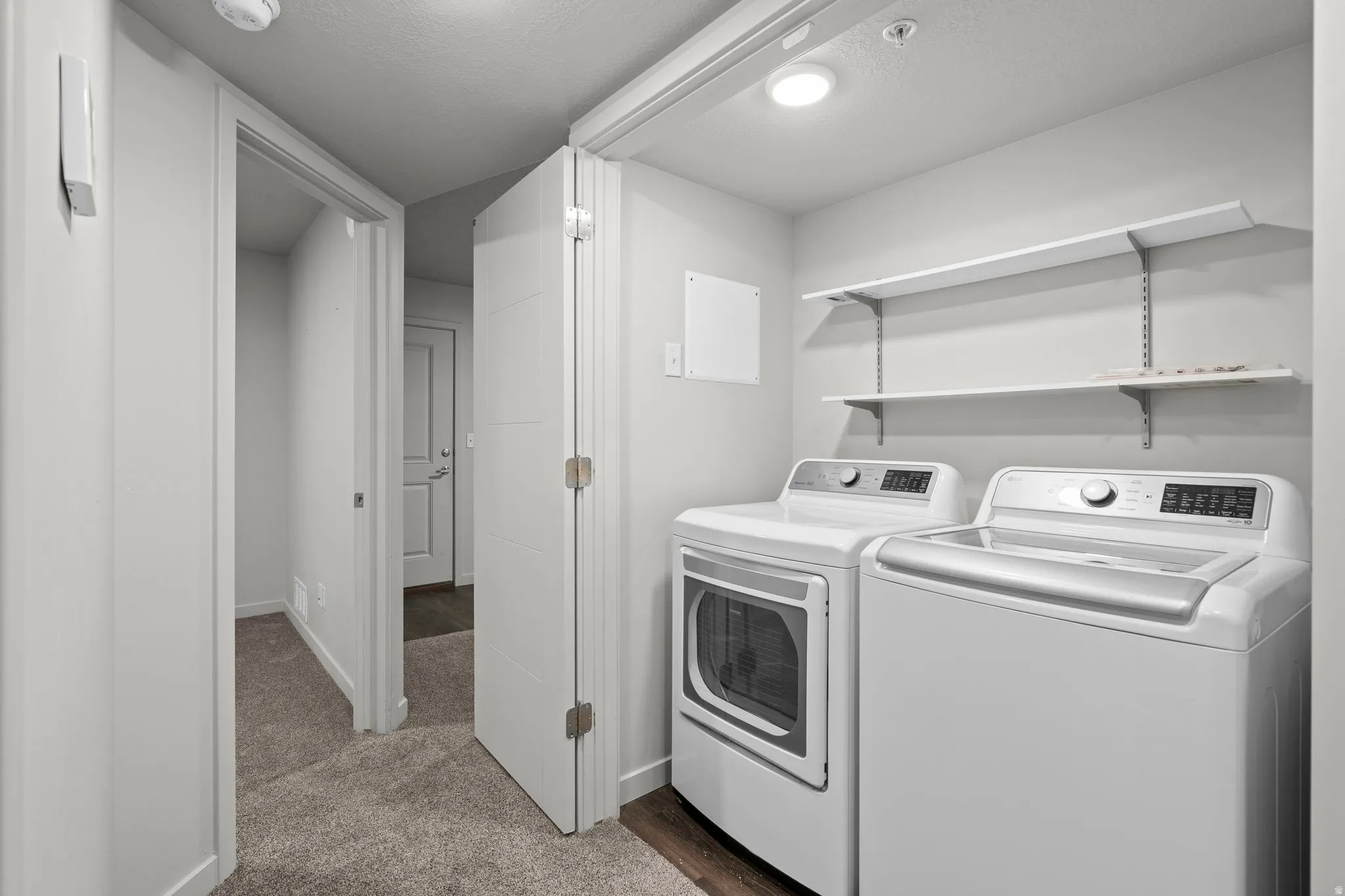 Dedicated laundry area featuring a washer and dryer, convenient overhead shelving, and recessed lighting