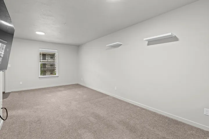 Spacious room featuring neutral wall finishes, recessed ceiling lighting, and plush carpet flooring