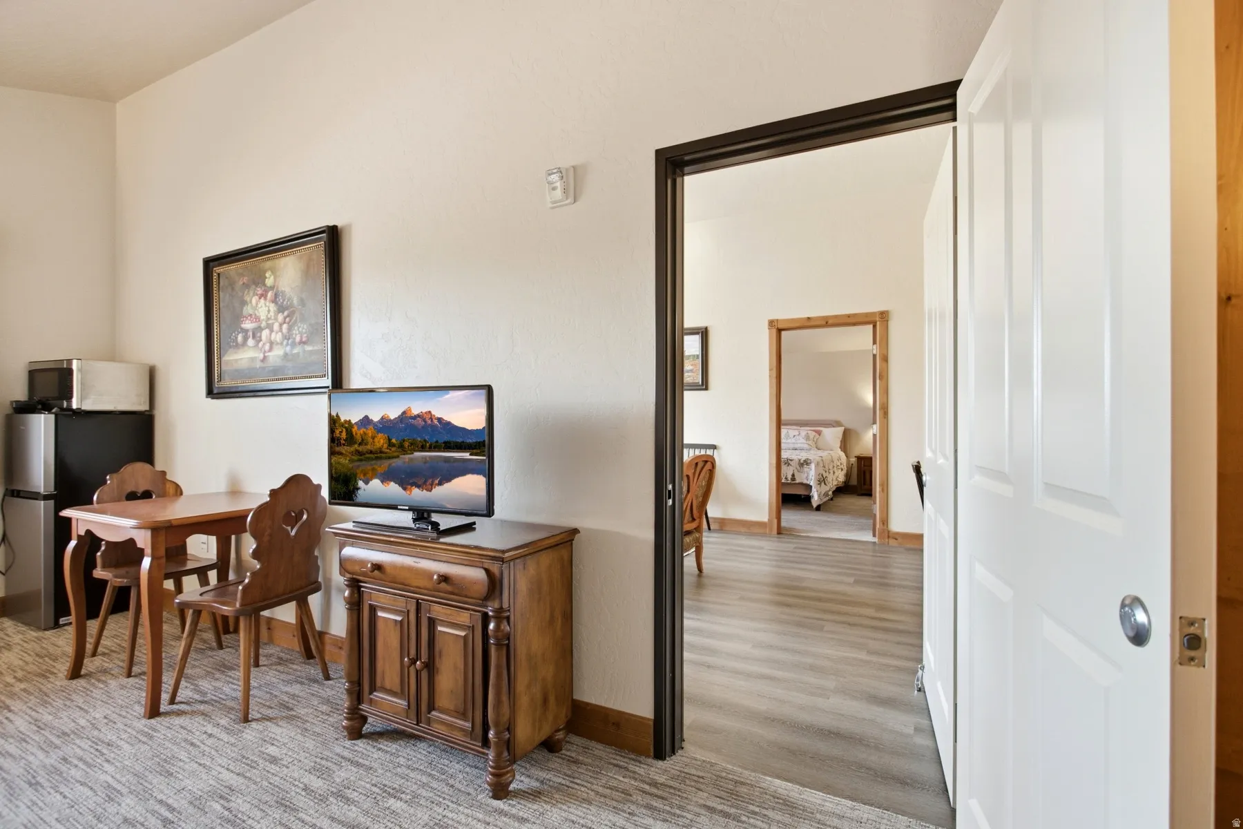 Inviting room featuring a wood-finish floor entryway, crisp white walls, and a recessed doorway