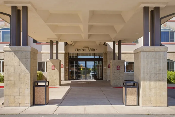 Covered entryway featuring large stone-clad pillars supporting a substantial canopy