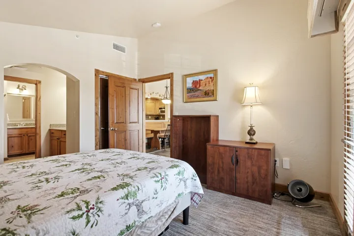 Spacious room featuring vaulted ceilings, wood-finish flooring, and natural wood doors