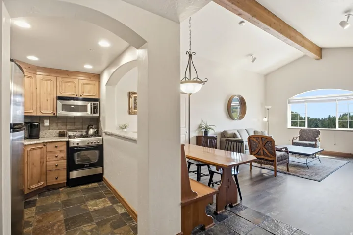 Open-concept living area with vaulted ceilings and exposed wood beams
