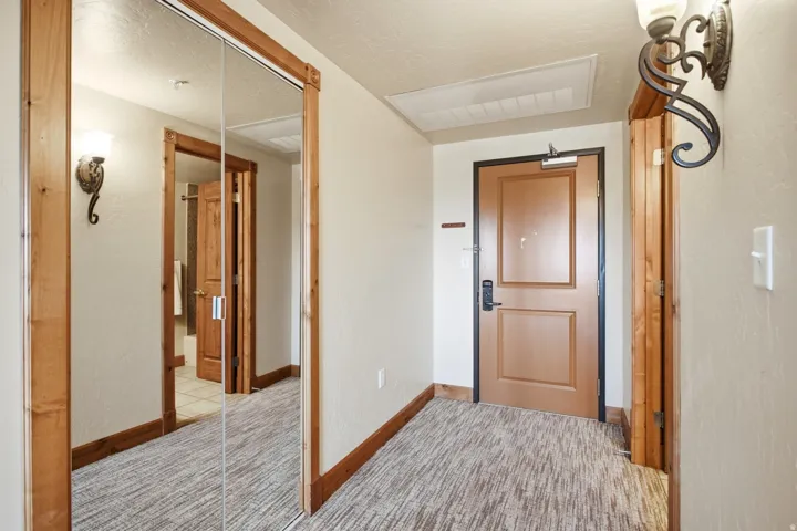Welcoming foyer featuring warm wood-trimmed architectural details, neutral wall finishes, and a blend of natural and recessed lighting