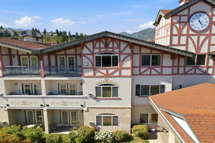 Charming Tudor-style residence featuring distinctive half-timber exterior detailing with cream and earth-tone facade, multi-level architecture with varied rooflines, and copper-toned pitched roof sections