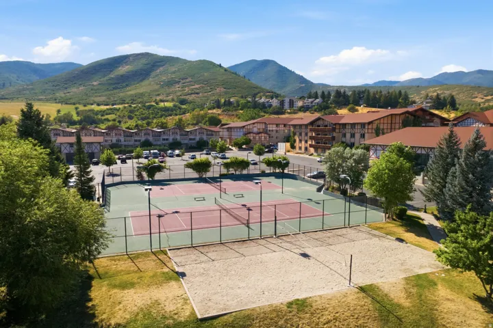 Outdoor recreational area featuring multiple tennis courts and a sand volleyball court