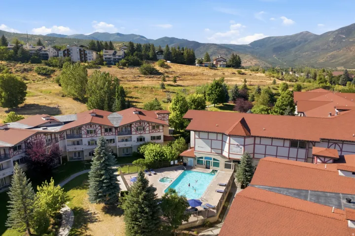 Multi-story property featuring a shared outdoor swimming pool and spa