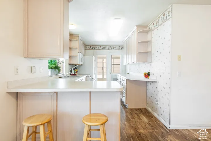 Kitchen featuring wood-finish flooring, extensive cabinetry, and a double-basin sink