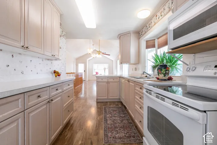 Kitchen featuring light-toned cabinetry, pull out shelves, light countertops, Pantry, and wood-finish flooring