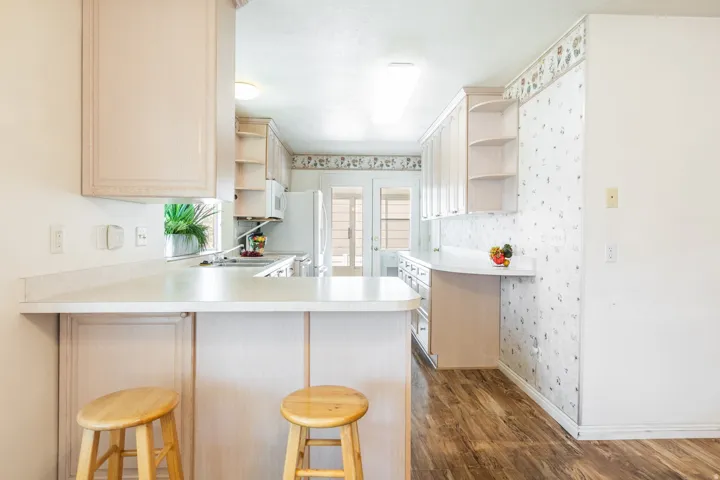 Kitchen featuring wood-finish flooring, extensive cabinetry, and a double-basin sink