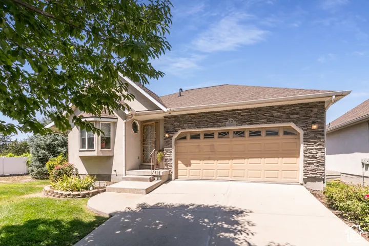 Rambler located close to Everything.  Stucco and stone facade with a two-car garage, with concrete driveway, and front entry with a full-light door. Garage has built in storage.